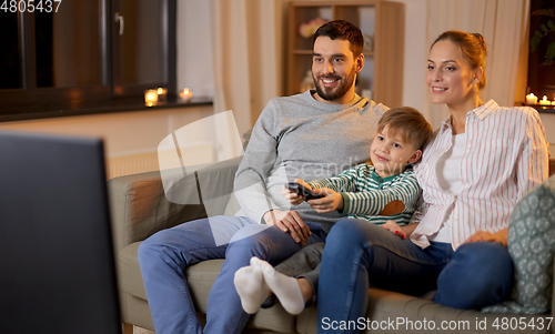 Image of happy family watching tv at home at night
