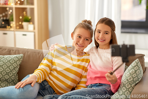 Image of happy girls taking selfie with smartphone at home