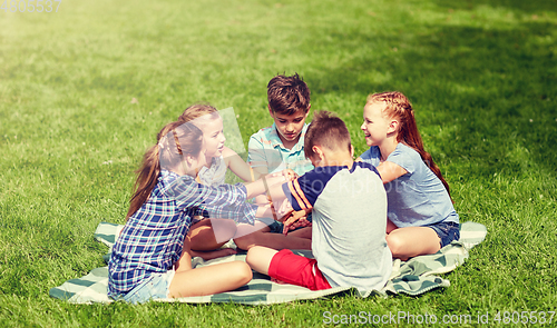 Image of group of happy kids putting hands together