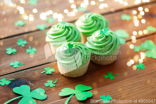 Image of green cupcakes and shamrock on wooden table