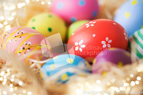 Image of close up of colored easter eggs in straw