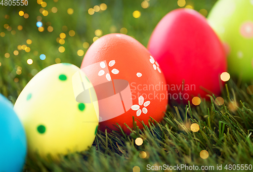 Image of row of colored easter eggs on artificial grass