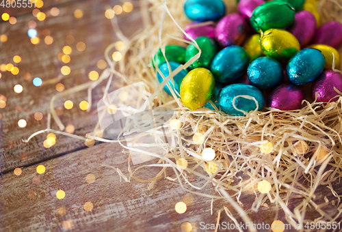 Image of chocolate eggs in foil wrappers in straw nest