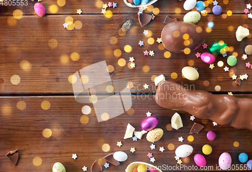 Image of chocolate eggs, easter bunny and candies on wood