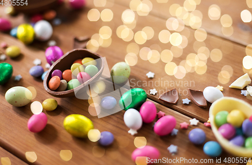 Image of chocolate eggs and candy drops on wooden table