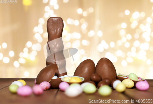 Image of chocolate eggs, easter bunny over festive lights