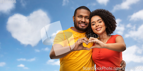 Image of happy african american couple making hand heart