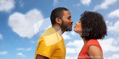 Image of happy african american couple reaching for kiss