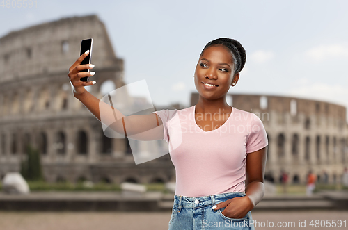 Image of african american woman taking selfie over coliseum