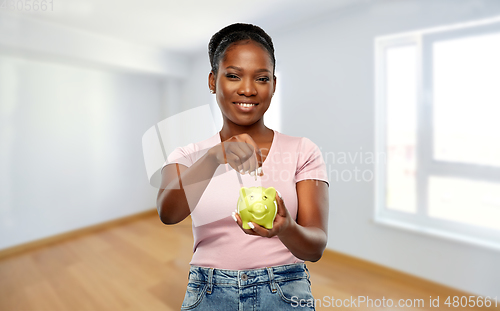 Image of african american woman with piggy bank at new home