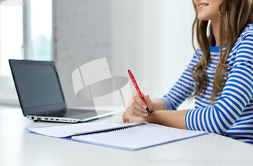 Image of student girl with exercise book, pen and laptop