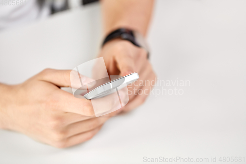 Image of close up of male hands with smartphone