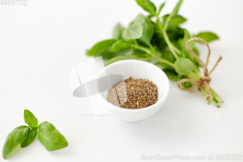 Image of fresh basil and dry seasoning on white background