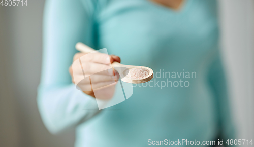 Image of close up of woman with sea salt on wooden spoon