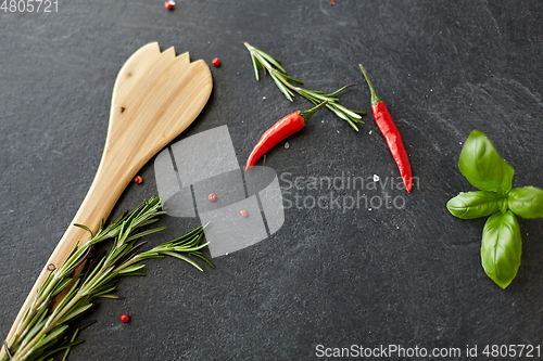 Image of rosemary, basil and chili pepper on stone surface