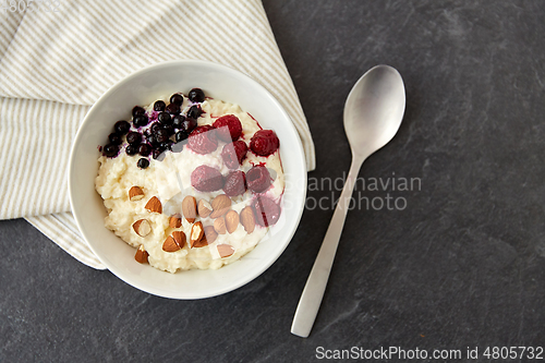 Image of porridge breakfast with berries, almonds and spoon