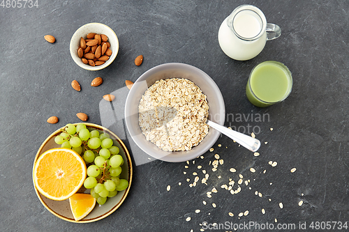 Image of oatmeal with fruits, almond nuts and jug of milk