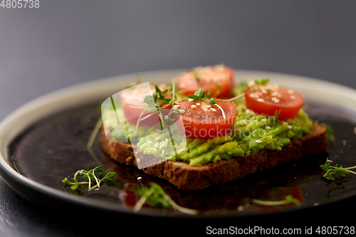 Image of toast bread with mashed avocado and cherry tomato