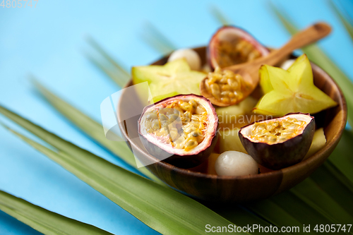 Image of mix of exotic fruits in wooden plate with spoon