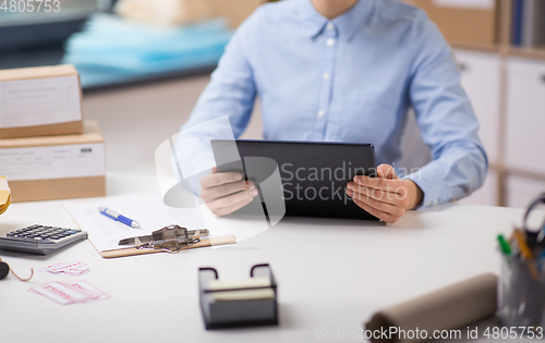 Image of woman with tablet pc and clipboard at post office