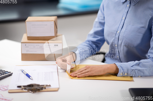 Image of woman removing sticker from envelope with parcel