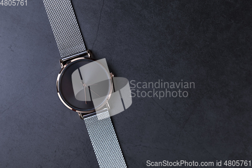 Image of Wrist watch with metal strap for women on gray background