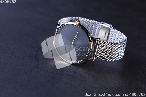 Image of Wrist watch with metal strap for women on gray background