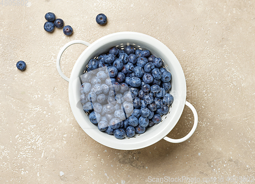 Image of fresh blueberries in a white metal sieve