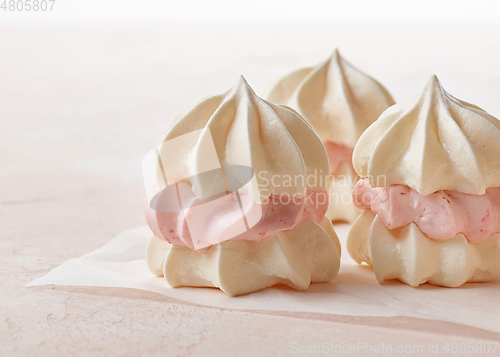 Image of meringue cakes on pink background