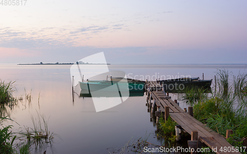 Image of Wooden Pier with Moored Boats on the Lake During Dawn