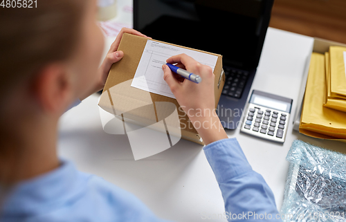 Image of close up of woman filling postal form at office