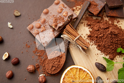 Image of chocolate with hazelnuts, cocoa beans and powder