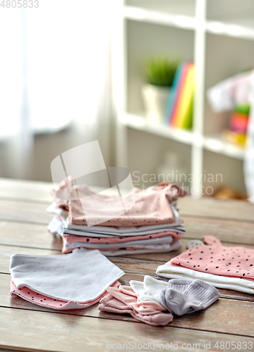Image of baby clothes on wooden table at home