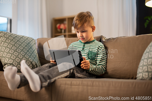 Image of happy little boy with tablet computer at home