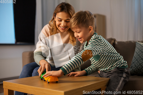 Image of mother and son playing with toy cars at home