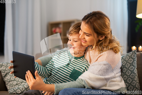 Image of mother and son using tablet computer at home