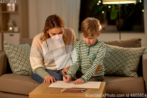 Image of mother and son with pencils drawing at home