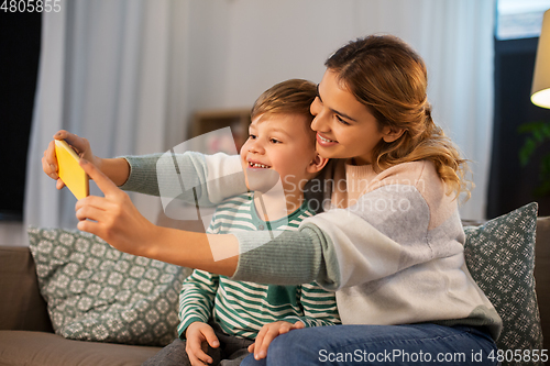 Image of mother and son taking selfie by smartphone at home