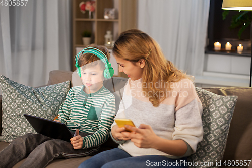 Image of mother and son using gadgets at home