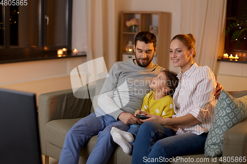 Image of happy family watching tv at home at night