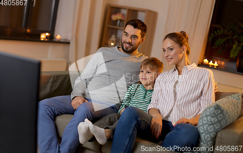 Image of happy family watching tv at home at night
