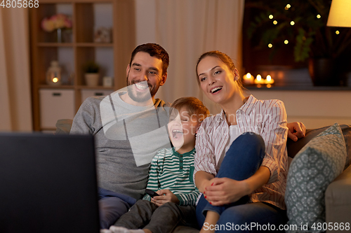 Image of happy family watching tv at home at night