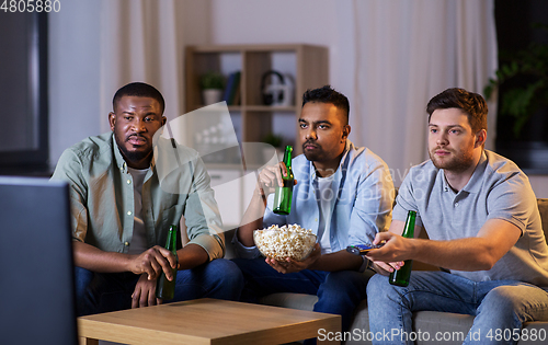 Image of male friends with beer watching tv at home