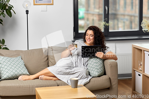 Image of woman with tablet pc and credit card at home