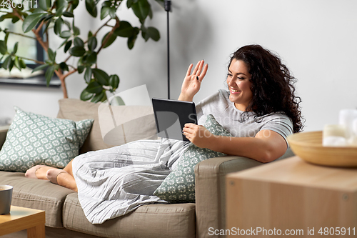 Image of woman with tablet pc having video chat at home