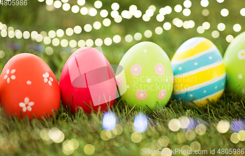 Image of row of colored easter eggs on artificial grass