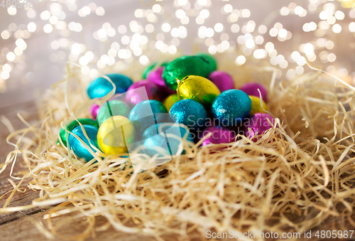 Image of chocolate eggs in foil wrappers in straw nest