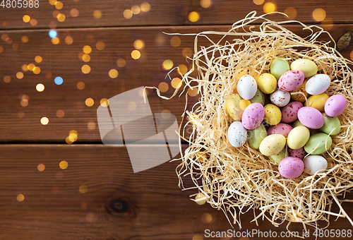 Image of easter eggs in straw nest on wooden table