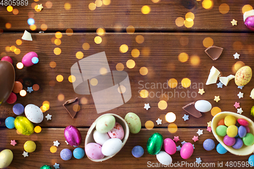 Image of chocolate eggs and candy drops on wooden table