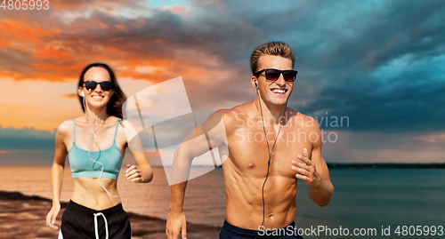 Image of couple with earphones running over sea
